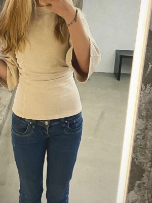 Beige topp med vida ärmar - Säljer en beige topp med trekvartsärm och vida ärmar. Toppen är tillverkad i mjukt bomullsmaterial. Kan diskutera priset 💛