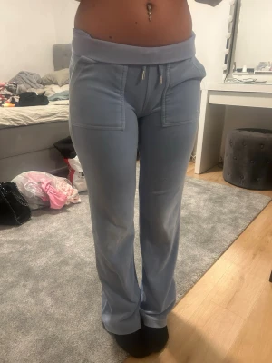 Ljusblå mjukisbyxor med fickor - Säljer ett par ljusblå mjukisbyxor med raka ben och bred resår i midjan. Byxorna har stora fickor fram med  och bakfickor med lock. Mjukt och skönt material 