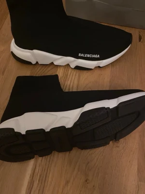  Trainer sneakers - Säljer ett par svarta  Trainer sneakers med vit chunky sula och stickad strumpliknande ovandel. Ikonisk logga på sidan och superbekväm passform. Kommer med originalpåse och shoppingbag.