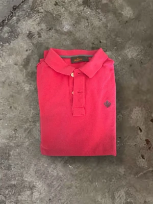 Röd Piké från Morris  - Säljer en röd pikétröja från Morris Stockholm i storlek XS. Tröjan är i mycket bra skick utan några defekter. Nypris ca 1000kr. Tröjan tvättas innan frakt.