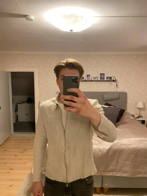Beige linne overshirt med dragkedja.  - Stilren beige J Lindeberg overshirt i linneblandning med rak passform och klassisk krage. Dragkedja framtill, bröstficka och knappar vid ärmslut. Perfekt lager på lager-plagg för en avslappnad look. Ny använts 2 gånger säljs pågrund av för liten för min smak.