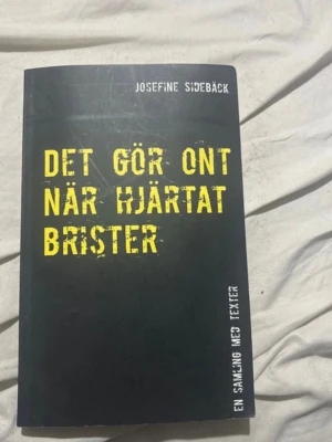 Det gör ont när hjärtat brister - En samling texter av Josefine Sidebäck om psykisk ohälsa, kärlek och livet. Boken har svart mjukt omslag med gul text och är tryckt av Books on Demand. Perfekt för dig som gillar starka känslor och ärlig skönlitteratur.