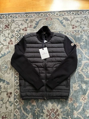 Svart Moncler cardigan - Helt ny Moncler cardigan endast testad tags och allt är på nfc fungerar givetvis priset är diskuterbart. Det är bara att höra av sig vid frågor mvh Edvin 