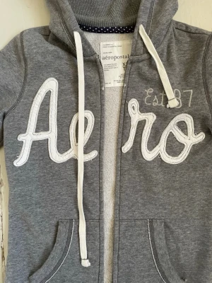 Aeropostale zip up hoodie - Grå hoodie från aeropostale, jättefin utan skavanker. Skriv vid frågor. Kolla gärna på mina andra plagg och skapa en bundle!💓📣✨