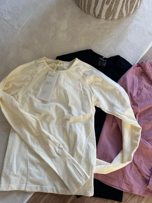 Långärmad träningströja  - Säljer 3 st långärmade träningströjor från hm. Svarta är i storlek M och den rosa och vita är i storlek S. Supersköna med hål för tummarna. Den vita har prislapp kvar.