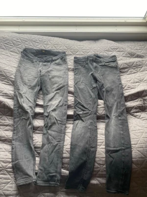Två par gråa slim jeans - Säljer två par gråa slim jeans i stretchigt denim. Båda har klassisk femficksdesign och normalhög midja. Perfekta för dig som gillar en smal siluett och vill ha ett par bekväma jeans till vardags. Snyggt slitna detaljer och neutrala färger som passar till allt.