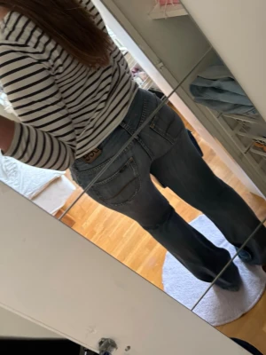 Blå bootcut jeans från Lee - Säljer ett par blå bootcut jeans från Lee med slitningar framtill och klassiska fem fickor. Skriv om du vill ha måtten🩷