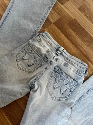 Ljusblå bootcut jeans från Gina 14+ - Säljer ett par ljusblå bootcut jeans från Gina Tricot i Storlek Xs-Tall med klassiska W-broderade bakfickor. Jeansen har fem fickor, bälteshällor och knappgylf. Materialet är denim i bomull med en snygg tvättad look och slitningar för en avslappnad stil. Älskar dessa jenas men dom har tyvärr blivit för små, det finns ett litet hål som man ser på sista bilden men det syns inte så mycket och går att laga. Priset går att diskutera vid snabbt köp!
