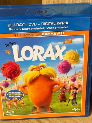 Lorax Blu-ray + DVD + Digital - Säljer filmen Lorax på Blu-ray, DVD och digital kopia. Omslaget är färgglatt med Lorax-figuren i orange och fluffiga träd i bakgrunden. Filmen är animerad och baserad på Dr. Seuss bok. Innehåller även tre roliga minifilmer och bonusmaterial.