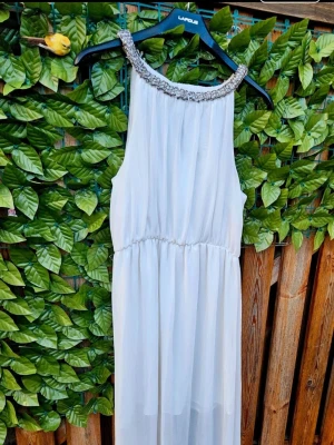 Vit maxiklänning med pärldetaljer - Säljer en elegant vit maxiklänning från Ginatricot. I storlek 36 men passar även upp till S/M . Klänningen har markerad midja och ett skirt, flowy tyg som ger en drömmig känsla. Perfekt för sommarens alla tillfällen!