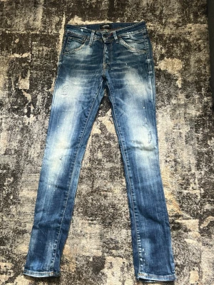 Blå slim fit jeans från Jack & Jones - Snygga blå slim fit jeans från Jack & Jones med slitna detaljer och ljusa tvättade partier. Klassisk femficksmodell med knappgylf och smal passform. Perfekta för sommaren!