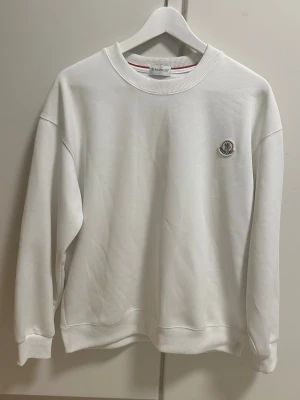 Moncler sweatshirt  - Vit sweatshirt från Moncler med rund halsringning. Är tillverkad i mjukt material. Pris går alltid att diskuteras 💯