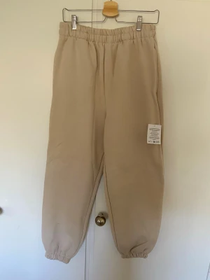 Beige mjukisbyxor från Arrange, Asos  - Beiga mjukisbyxor från Arrange, Asos med resår i midjan + band på insidan (se bild 4) och vid ben sluten. Lena och mjuka på insidan. Storlek S men skulle mer säga M. Aldrig använda, prislappen kvar. 