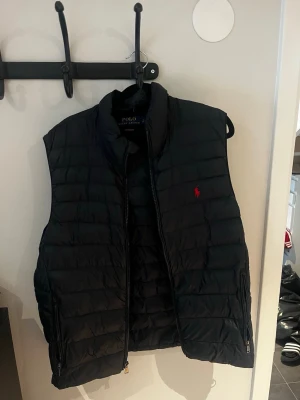  Polo Ralph Lauren Väst - Snygg mörkblå väst från Polo Ralph Lauren köpt från Zalando, den är i mycket bra skick då jag använt den varsamt och endast använt den vid ett fåtal tillfällen. Nypriset för västen är 2900 kronor, jag säljer den endast för 1299 kronor. Det är bara att höra av er i dm vid ev frågor eller funderingar!