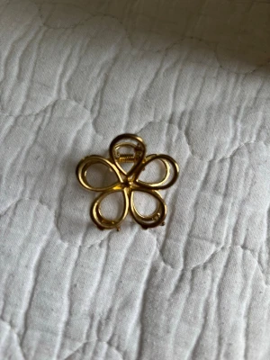 Guldig blomformad hårklämma🫶🏻 - Snygg hårklämma i metall med guldig finish, formad som en blomma med fem kronblad. Perfekt accessoar för att ge frisyren en trendig och stilren touch. Klämman är lätt och smidig att använda för att hålla håret på plats. Jätte söt!🤍