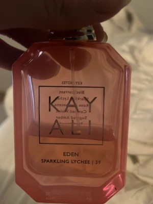Kayali Eden Sparkling Lychee parfym - Fräsch parfym från Kayali i modellen Eden Sparkling Lychee. 20 ml kvar.  Doften har noter av svartvinbär, litchi, ros, sockrad viol, bärnsten och sandelträ. 
