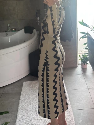 Beige långklänning med svart mönster -  Fin klänning i trevligt material från NAKD i storlek small. Använd ett fåtal gånger, jättefint skick. Nypris 799kr, kom gärna med prisförslag💕
