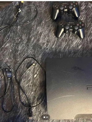 PlayStation 3 Slim med två kontroller - PlayStation 3 Slim i svart med två trådlösa DualShock 3-kontroller och tillhörande kablar. Konsolen har en stilren, matt finish och är tillverkad i plast. Perfekt för gamingkvällar och multiplayer med vänner.
