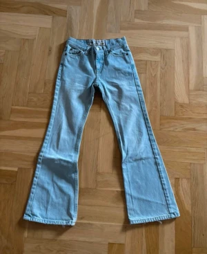 Ljusblå bootcut jeans från Crocker - Säljer ett par ljusblå jeans från Crocker med klassisk bootcut-modell. Jeansen har fem fickor, bälteshällor och stängs med knapp och dragkedja. Perfekta för dig som gillar retrovibbar och en avslappnad look.