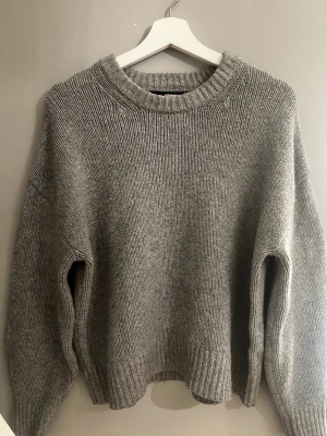 Grå stickad tröja med rund hals bik bok  - Mysig grå stickad tröja med rund halsringning och ribbade muddar vid ärmslut och nederkant. Tröjan har en avslappnad passform och är perfekt för kyliga dagar. Passar till allt och är enkel att styla för en casual look priset går att diskutera 🩷