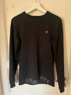Svart sweatshirt från Lyle & Scott - Säljer en Svart sweatshirt från Lyle & Scott Junior med rund halsringning och ribbade muddar. Liten gul logga på bröstet och tryckt text längst ner. Perfekt för en avslappnad och stilren look. Hör av dig vid frågor🙌🏼