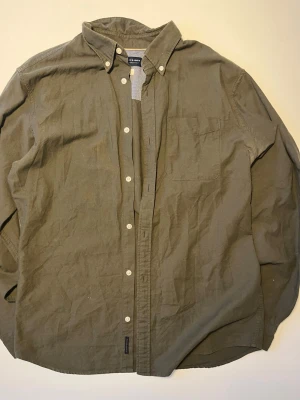 Jack & Jones Skjorta - Olivgrön skjorta från Premium by Jack & Jones. Knäppning fram, bröstficka, klassisk skjortkrage. Storlek L men sitter även bra som M för den som gillar en lite rymligare passform.  Storlek: L (passar M)  Skick: Mycket Bra  Märke: Premium by Jack & Jones  Färg: Grön/Khaki   Skickas snabbt 📦
