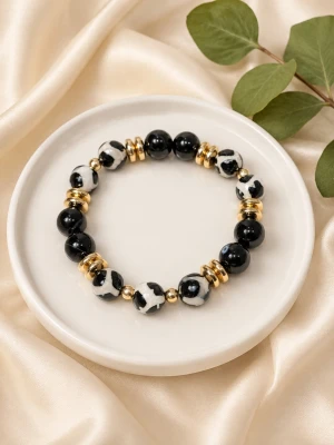 Armband med kristaller - Armband med tibetansk agat, onyx och hematit. Elastiskt. Ca 17 cm. Matchande örhängen finns att köpa till. Se separat annons.  Tibetansk agat sägs bringa tur, lycka och hälsa till bäraren.