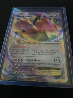 Dragonite EX Pokémonkort holografiskt - Säljer ett Dragonite EX Pokémonkort med holografisk yta. Kortet har 180 HP och attacken Hyper Beam. Det är färgglatt med motiv av Dragonite och ligger i ett plastfodral. Perfekt för samlare eller Pokémonfans!