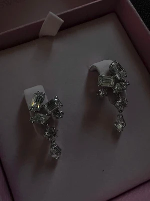 Swarovski Mesmera Örhängen - Swarovski Mesmera örhängen, använda endast en gång och i nyskick. Beställda från Kulta-Center.  ✨ Nypris: 1 450 kr ✨ Kvitto/beställningsbekräftelse finns kvar.