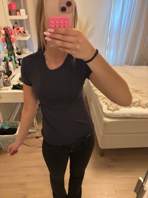 Mörkblå basic t-shirt - En enkel och stilren mörkblå t-shirt med rund hals och korta ärmar. Perfekt till jeans eller shorts och lätt att matcha med andra plagg. Tillverkad i mjuk bomull för skön känsla hela dagen.