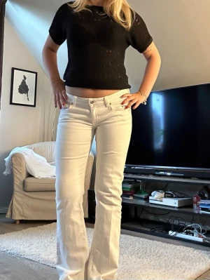 Vita bootcut jeans med låg midja - Snygga vita bootcut jeans med låg midja och klassiska fem fickor. Dom är i storlek M men funkar jätte bra som storlek S. Jag är ca 168cm och dom är jätte bra i längden! Dom är i super bra skick ändast lite defekter nere vid kanten på byxorna (se bild 3) säljer för att de inte används längre!🌸