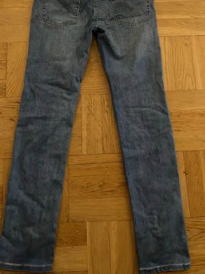 Levis Blå jeans 512 SLIM TAPER - Ett par blå jeans med rak passform och klassisk femficksdesign. Jeansen har normal midja och är tillverkade i denim med lätt tvättad look. Perfekta för en avslappnad stil och passar till det mesta.