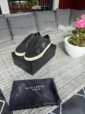Svarta Saint Laurent sneakers - Tjena, säljer ett par snygga skor från Saint Laurent. Skorna är i princip oanvända och riktigt fräscha. Tveka inte på att skriva för fler bilder eller om du undrar något Mvh Felkannn@