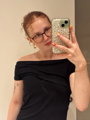 Svart offshoulder topp - Säljer en svart offshoulder topp. Materialet känns mjukt och stretchigt, vilket gör den bekväm att bära. Inga synliga detaljer eller mönster, bara clean svart look.