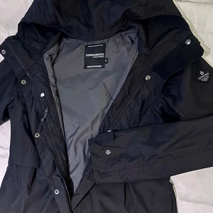 Svart Didriksons Jolina Parka stl 36 | Nyskick - Säljer en supersnygg svart Didriksons Jolina parka i dammodell, storlek 36. Endast använd ett fåtal gånger, så den är i absolut nyskick! Inga hål, fläckar eller skador. Jackan har StormSystem och är 100% vind- och vattentät med tejpade sömmar. Praktisk innerficka med blixtlås.  📐 Mått (mätt platt): * Bröstvidd: ca 49cm * Längd: ca 82cm * Arm: ca 63cm * Axelmått: ca 40cm.                                              Perfekt som skaljacka till vår, sommar och höst!