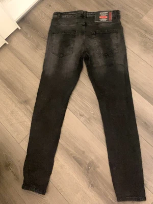 Svarta skinny jeans från Dsquared2 - Säljer ett par svarta skinny jeans från Dsquared2 med klassisk femficksdesign och snygg tvättad look. Jeansen har en tydlig Dsquared2-lapp bak i midjan och smal passform som sitter tight längs benen. Perfekta för dig som gillar streetwear och trendig stil.
