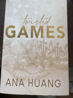 Twisted Games av Ana Huang - Twisted Games är en skönlitterär bok med ett elegant omslag i vitt och guld. Omslaget pryds av pärlhalsband och en glittrande krona, vilket ger en lyxig och romantisk känsla. Perfekt för dig som gillar romantik och drama. Aldrig läst den, hellt ny. Säljer den för 200kr. Men priset kan diskuteras 💗