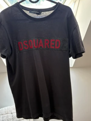 Svart DSQUARED2 - Tja säljer denna DSQUARED2 T-shirt som e väldigt unik och snygg, den e nästan helt oanvänd och inga defekter 