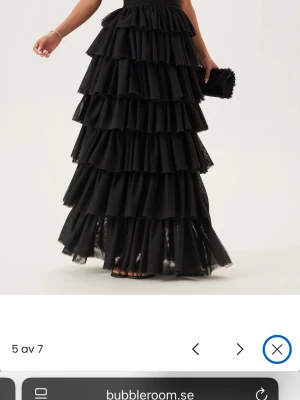 Svart volangklänning från Bubbleroom - Svart volang klänning från bubbleroom. Inte helt original från butik då jag gjort några ändringar på den. Klippt bort ett band på ryggen som gick mellan axelbanden nedanför nacken, samt bytt dragkedja då den vart i dåligt skick. Köptes utav mig våren 2025, använts en kväll. Köptes utav mig för 800 kr, och ny kostar den ca 1000 kr. Fint skick men då den inte är original så är priset reducerat. 