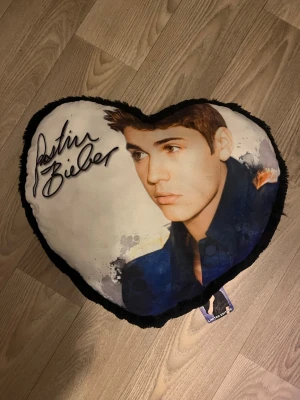 Hjärtkudde med Justin Bieber-tryck - Hjärtkudde i svart och vitt med tryck av Justin Bieber. Köpt på Hemtex för 200kr.