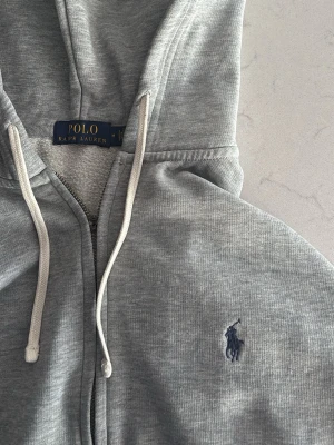 Polo ralph lauren zip  - Säljer en fet zip från polo ralph lauren skicket är bra förutom att den man drar dragkedjan med är borta annars felfri.