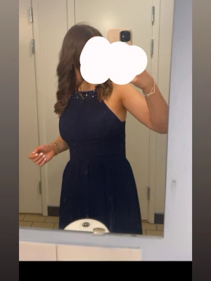 Balklänning mörkblå - En mörkblå balklänning med pärldetaljer. Den har några små vitafläckar längst ner som man kan se på sista bilderna, skriv så kan jag skicka tydligare.