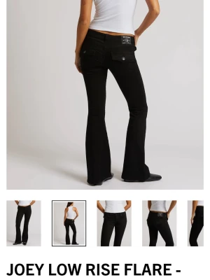 Svarta flare jeans från True Religion - Snygga svarta low rise flare jeans från True Religion med klassiska fickor och dekorativa knappar bak. Modellen heter Joey Low Rise Flare och har en utsvängd passform!💞💞