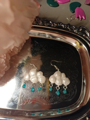 Regn moln örhängen - Handgjorda örhängen med regn moln. Schimriga moln med genomskinliga vattendroppar. One of a kind Denna är Handgjord av lera och resin därav priset. Om intresse fins kan jag göra flera