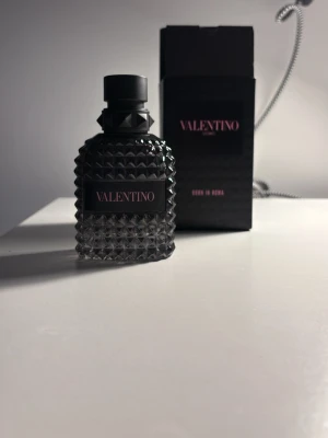 Valentino Born In Roma EdT 50ml - Valentino Born In Roma Eau de Toilette i en snygg, mörk glasflaska med nitar och svart etikett. Flaskan rymmer 50 ml och har en lyxig, edgy design som sticker ut på hyllan. Perfekt för dig som gillar exklusiva dofter och coola detaljer. 41ml kvar!