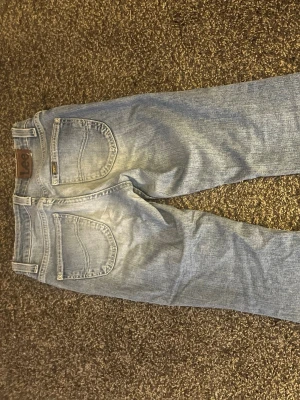 Ljusblå bootcut jeans från Lee - Säljer ett par ljusblå jeans från Lee med klassisk bootcut passform. Storlek XS, passar super bra i längden på mig som är 163 cm. 