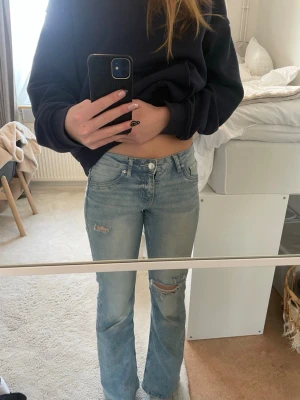 Ljusblå bootcut jeans - 💕Storlek: Skulle säga xs-s, är 175cm o de är aningen för korta💕 🤍Har gjort hålen på jeansen själv🤍 Ljusblå stretchiga jeans från H&M, säljs inte längre