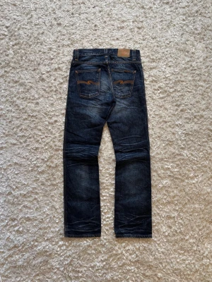 Nudie jeans slim jim vintage japan - Snygga jeans från nudie i modellen slim Jim, de är straight i passformen. Mycket bra skick. Storleken 30/32. Tveka inte på o skriva vid fler frågor! Hela längden: 106 cm Innerben: 84 cm Midja: 40 cm Benöppning: 20/21 cm