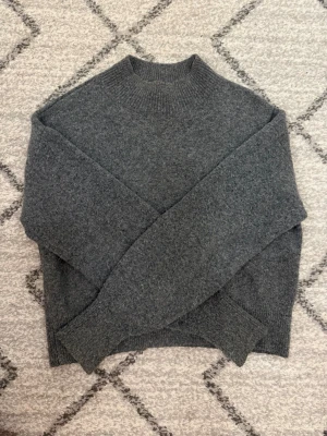 Grå stickad tröja från & Other Stories - Mysig grå stickad tröja från & Other Stories med hög hals och ribbade muddar. Fin stickad och sticks inte alls! Tryck inte på köp innan ni kontaktat mig! 