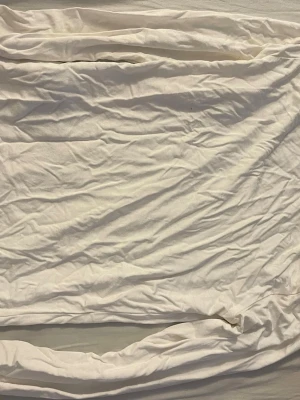 Vit basic t-shirt från Gina Tricot - En klassisk vit t-shirt från Gina Tricot i mjuk bomull. Enkel och stilren design med rund halsringning och korta ärmar. Perfekt att matcha med allt i garderoben och superbekväm att bära hela dagen.